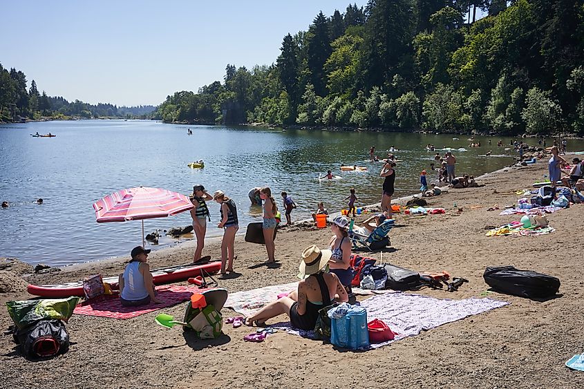 Lake Oswego, OR, USA - July 20, 2020: The Willamette River beach in a Lake Oswego city park is packed with visitors on a hot summer day amid the coronavirus pandemic.