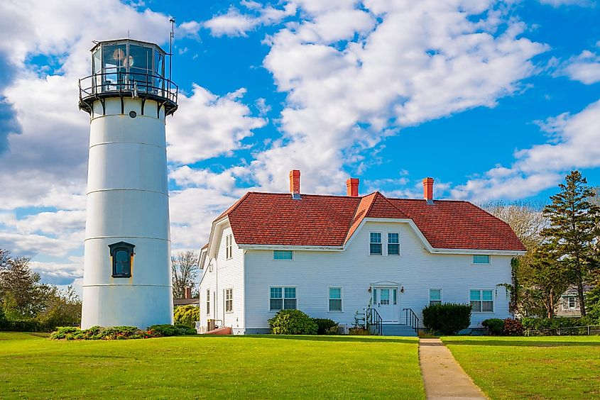 Chatham Light and the Red Roof Keeper's House under dramatic clouds in the blue sky.