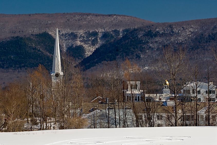 Morning scene of a snowy field with a silo in the distance and view of the Taconic Mountains in the background from Manchester, Vermont.