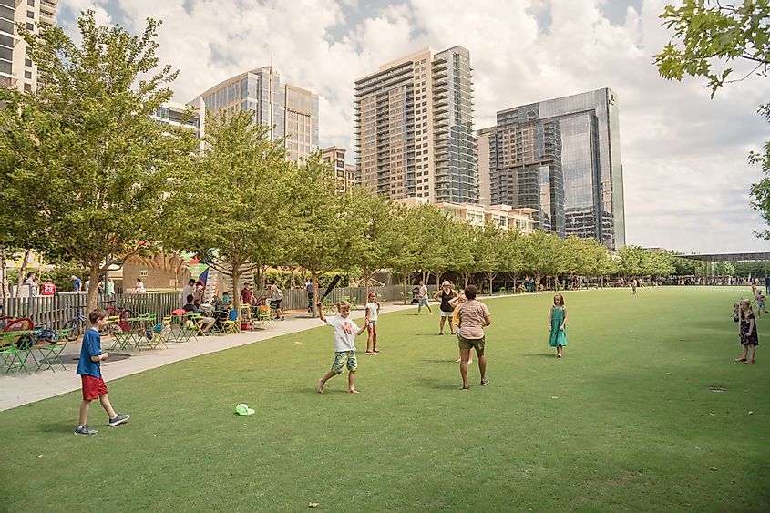 People playing sport on green lawn grass on a sunny day in Klyde Warren Park, Dallas, Texas