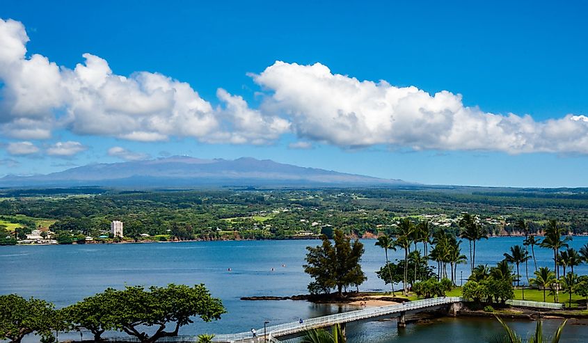 A view of Hilo, Hawaii and Mauna Kea on a clear day such that you can see the telescopes on the mountain peak.