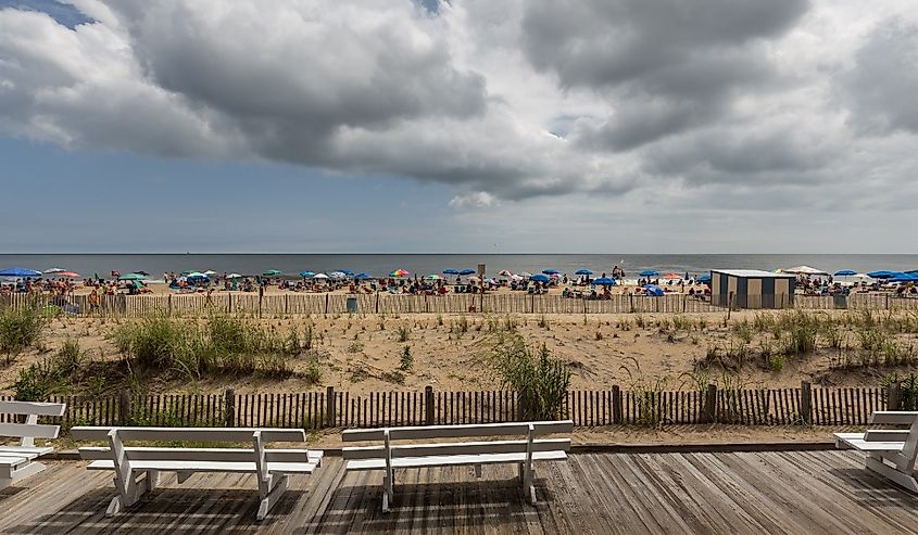 Overlooking umbrellas and people on Rehoboth Beach with clouds in the sky