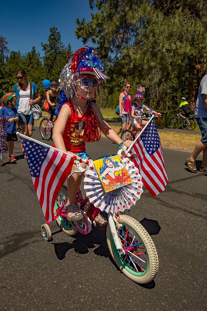 A young girl riding her decorated bike in a 4th of July parade at Black Butte Ranch resort near Sisters, Oregon.