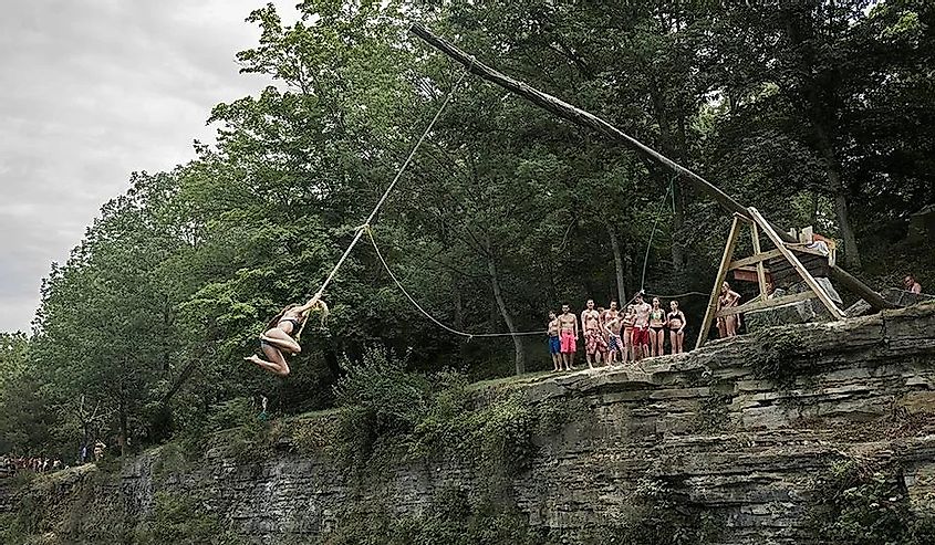 Tourists cliff diving by rope in White Rock Park 