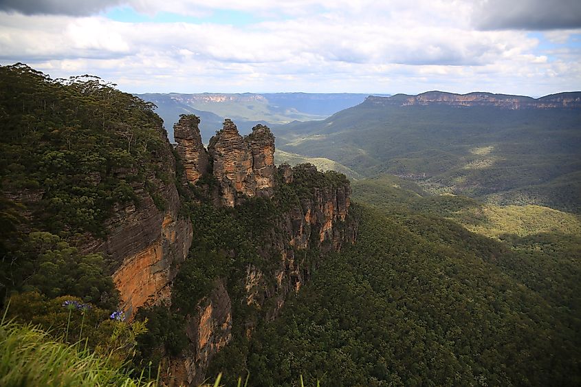 Sandstone cliffs and rock formations overlooking a forested valley.