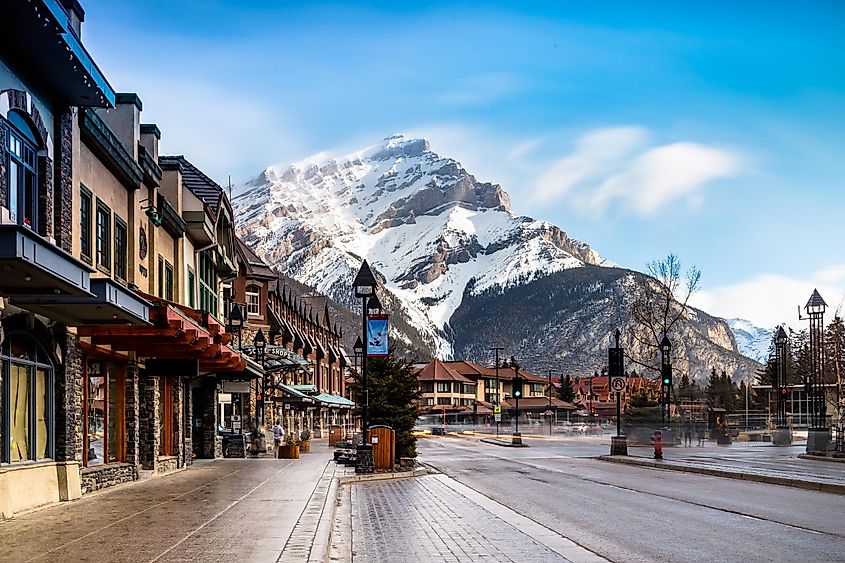 A street in Banff, Alberta at the base of a snow-capped mountain.