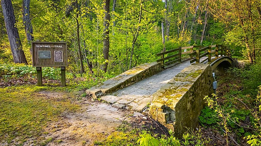 Stone bridge crossing Sentinel Trail through forested terrain in Mississippi Palisades State Park, Illinois.