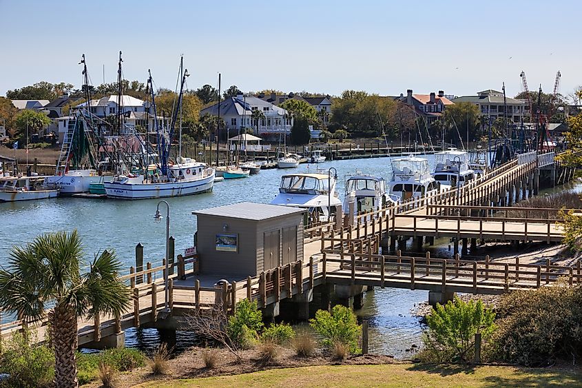 Shem Creek Boardwalk is a tourist attraction that offers views, a picturesque waterfront pathway, and several dining opportunities, via Cvandyke / Shutterstock.com