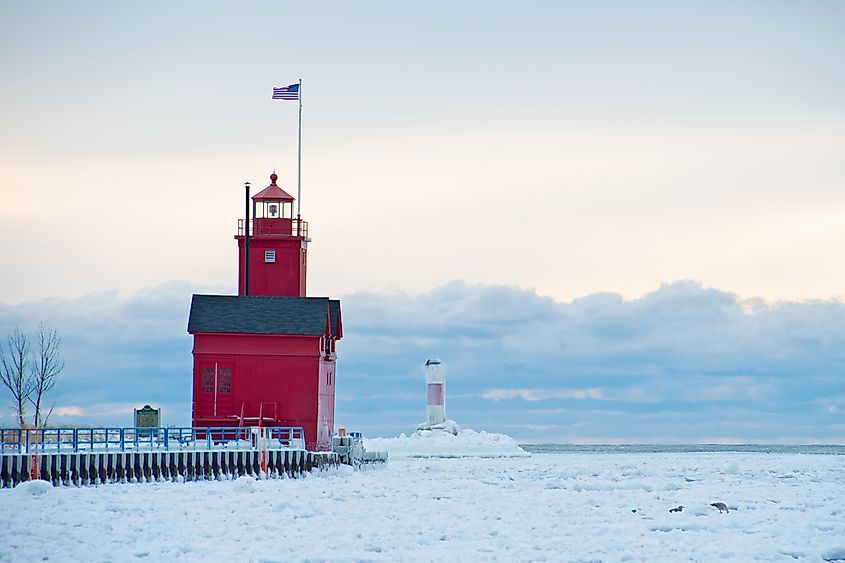 Big Red lighthouse in Holland Harbor channel in winter.