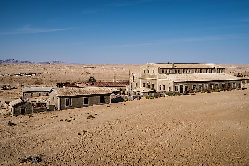 Abandoned buildings in the old diamond mining town of Kolmanskop near Luderitz, Namib Desert, Namibia.