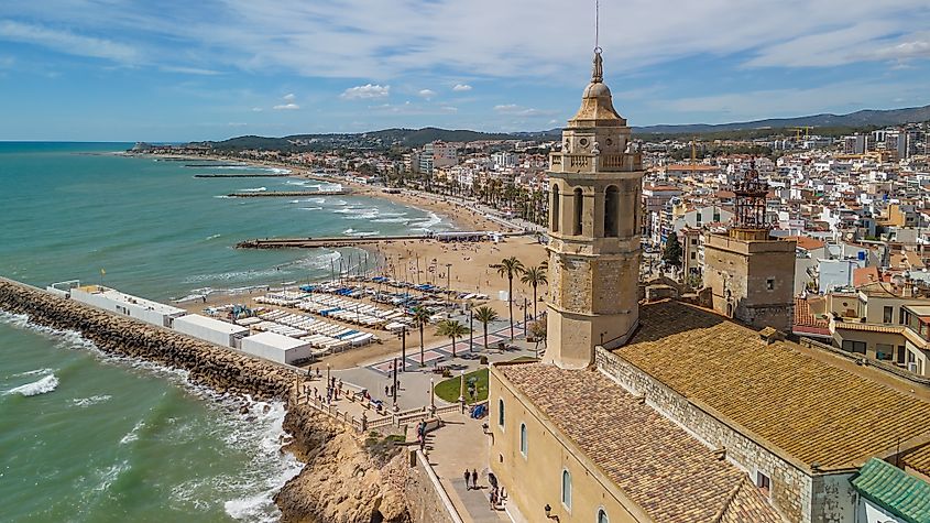 Aerial view of Sitges coastal town and the Iglesia de San Bartolome y Santa Tecla church on a sunny day in Sitges, Catalonia, Spain.