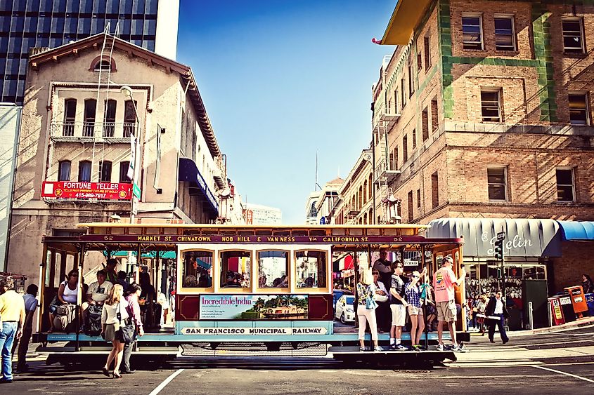Passengers enjoy a ride in a cable car in San Francisco, California