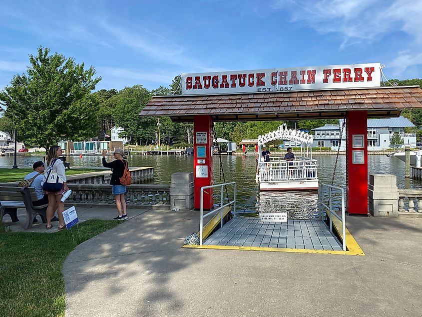 A small group of people wait as the Saugatuck Chain Ferry makes its way to the dock.