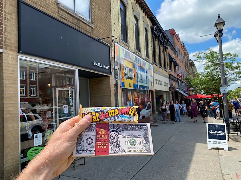 Holding up two retro chocolate bars outside of a small town candy store/mini mart.