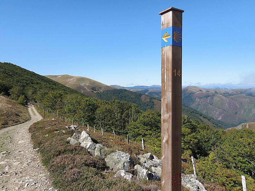 A Camino post marks the way as a trail leads through the foothills of the Pyrenees 