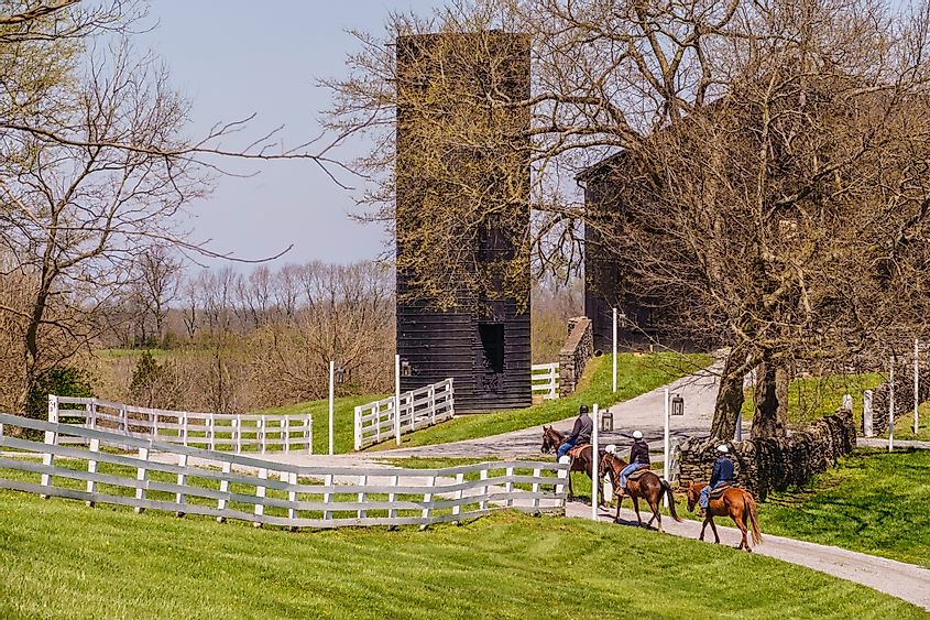 Three adult riders follow a trail toward an historic barn at the landmark destination of Shaker Village of Pleasant Hill on a sunny day in spring., Ken Schulze / Shutterstock.com