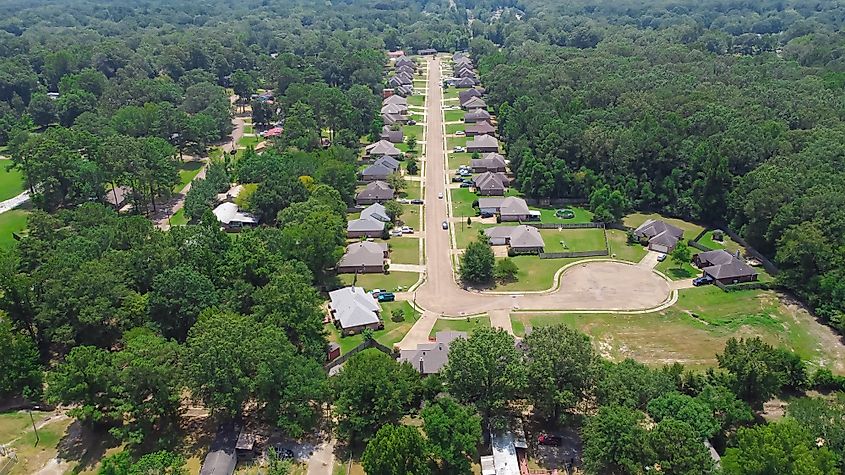 Quiet cul-de-sac, residential street along row of new development single family homes surrounding by lush green trees near Richland Westside Park, Mississippi