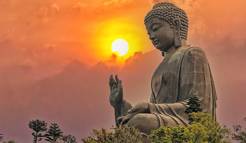Big bronze Amoghasiddhi Buddha statue called Tian Tan Buddha with sunset sky at Po Lin Monastery Ngong Ping in Lantau Island famous tourist destination in Hong Kong China