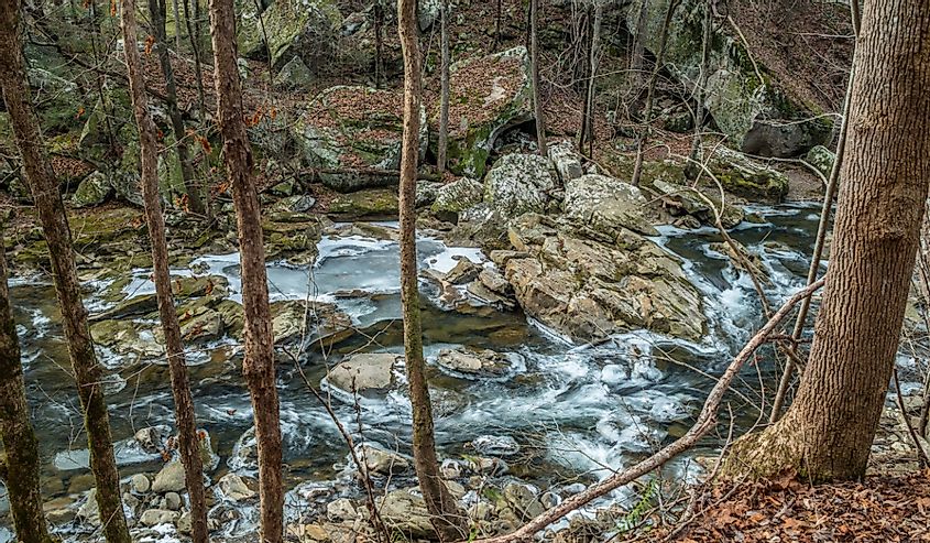 Looking down from the trail at the flowing partially frozen Richland creek in the pocket wilderness in Dayton Tennessee in wintertime