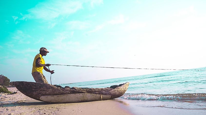 A fisherman anchoring his traditional boat alongside Lake Bangweulu.