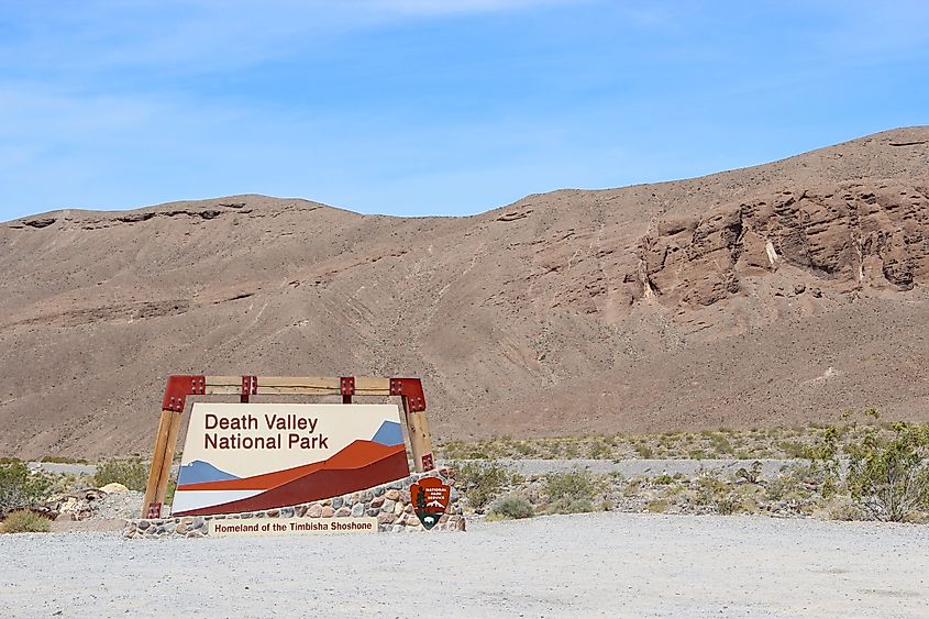 The sign for Death Valley National Park with mountains in the background.