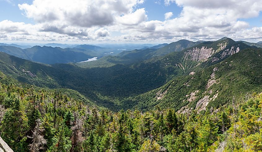 View from the summit of a mountain overlooking a big valley with lots of peaks on a sunny day. Shot on the Upper Wolfjaw mountain, Adirondacks National Park, NY, USA.