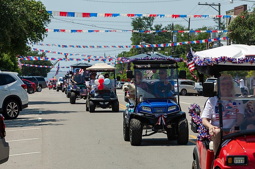 Southport, North Carolina: Vehicles decorated with US Flags on Parade on a Street to celebrate Independence Day, via christianthiel.net / Shutterstock.com