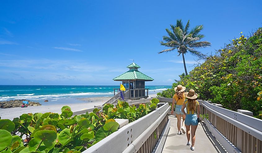 Women walking on boardwalk to beautiful Florida beach. Girls on summer vacation in Florida. Red Reef Park, Boca Raton,
