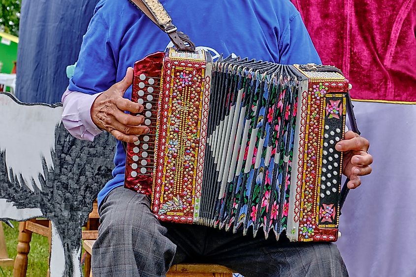 An accordion player with his instrument decorated with colorful rhinestones.