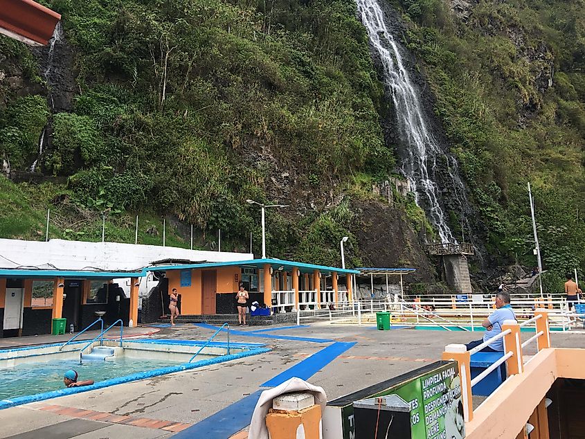 A collection of rustic hot springs beside a tropical waterfall