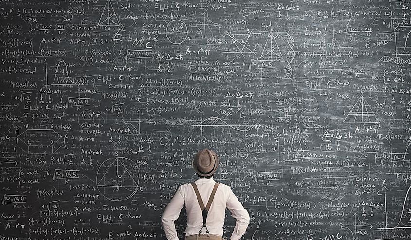 Man looking at a blackboard with complicated math equation.