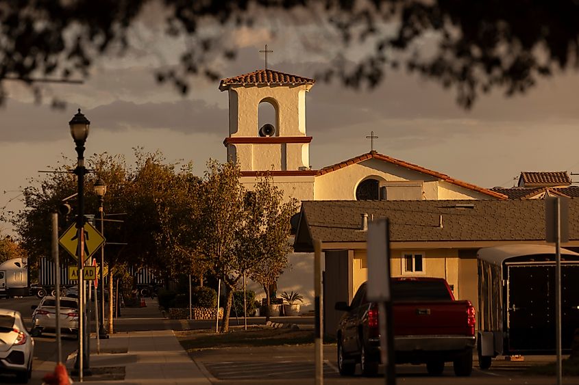 Setting sun shines on a historic church and buildings of downtown Firebaugh, California
