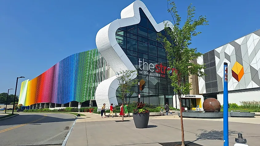 Visitors walk near the colorful facade of The Strong National Museum of Play