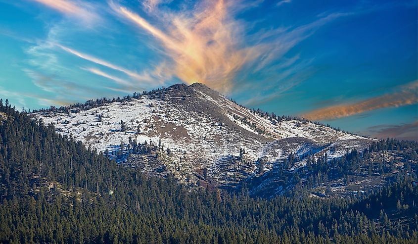 A gorgeous winter landscape with snow capped mountains surrounded by lush green trees at Lake Tahoe in Crystal Bay, Nevada.