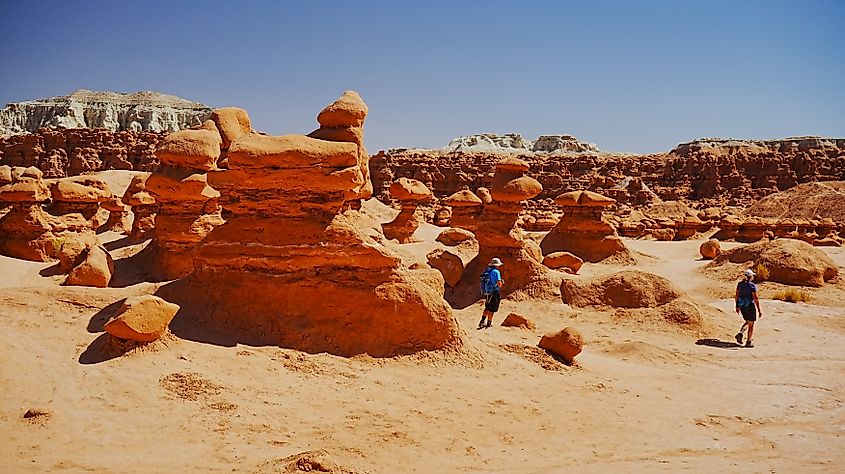 Hikers wandering the hoodoos at Goblin Valley State Park, Utah.