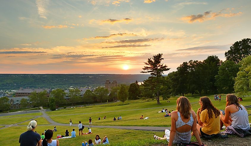Students at Libe Slope watch the sunset on the campus of Cornell University in Ithaca.