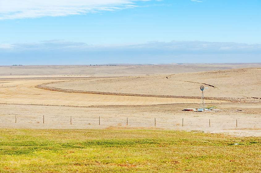 Lonely farm with wind turbine on vast prairies of Nebraska Great Plains.