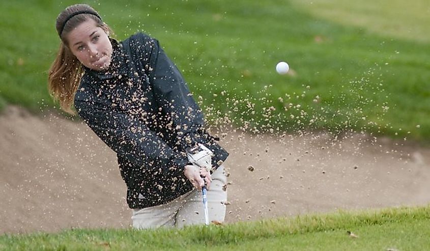 Lawrence Free State golfer Madison Brumley chips out of a sandtrap at the 18th green during the 6A girls state golf championships at Shadow Glen Country Club, in Olathe, Kansas.