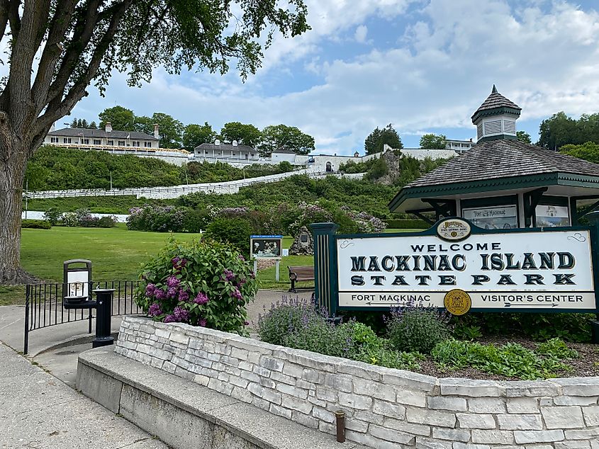 A lovely green park with a large sign indicating Mackinac Island State Park and Fort Mackinac (seen on the hill above). 