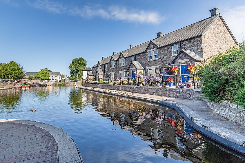 Cottages reflecting in the water of Brecon Canal basin in Brecon, Wales.
