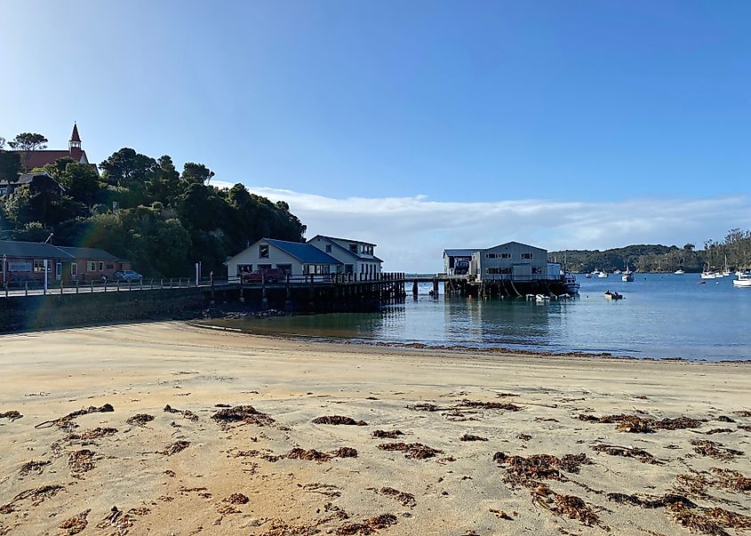 View across the sand to Oban township's ferry jetty and boat harbour, Stewart Island, New Zealand.