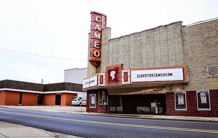 Historic theater with a beige facade and red accents, featuring a prominent vertical "Cameo" sign. Marquee displays "ilovethecameo.com." Quiet street scene.