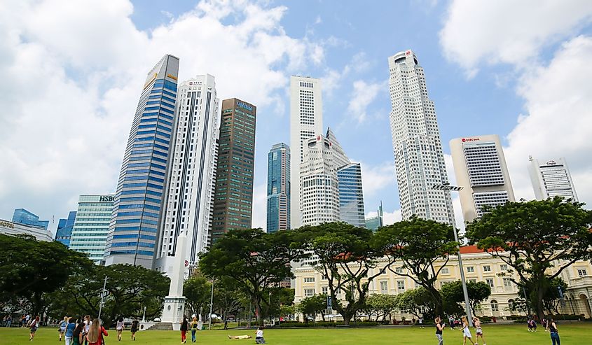 People on the grass in front of the Skyscrapers at Central Area in the center of Singapore.
