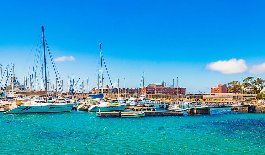 False Bay coast landscape with yachts boats jetty Long Beach and mountains in Simons Town Cape Town Western Cape South Africa..