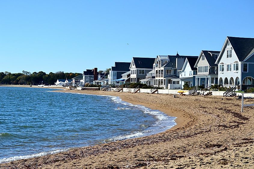 Sandy beach in Madison, Connecticut, USA, with houses along the shoreline.