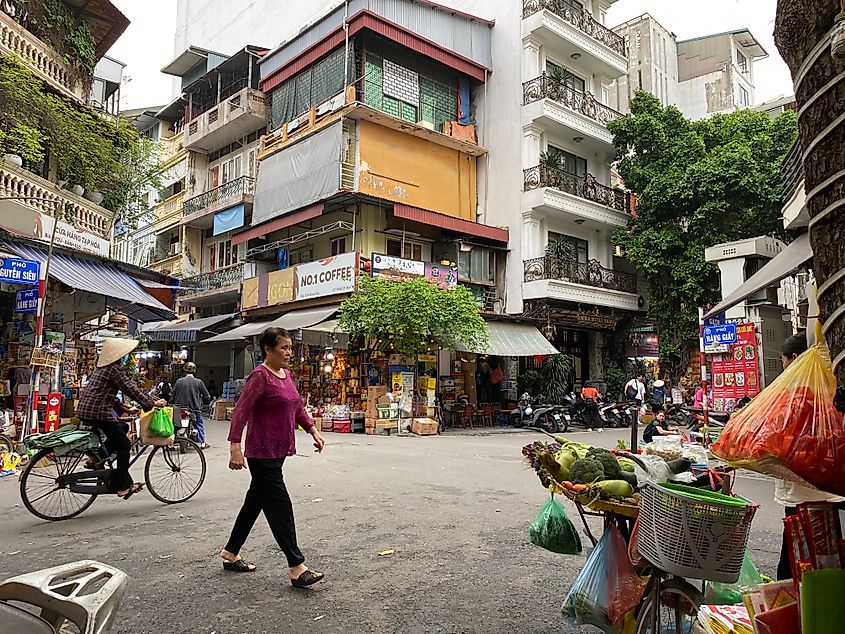 A typical scene in the Heart of Hanoi, Vietnam. Cyclists and pedestrians move amongst apartments, shops, and street vendors.