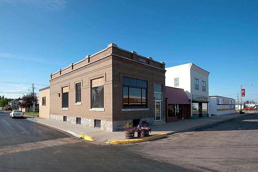 A sunny day in Walhalla, North Dakota, with a street view showing stores along the road.