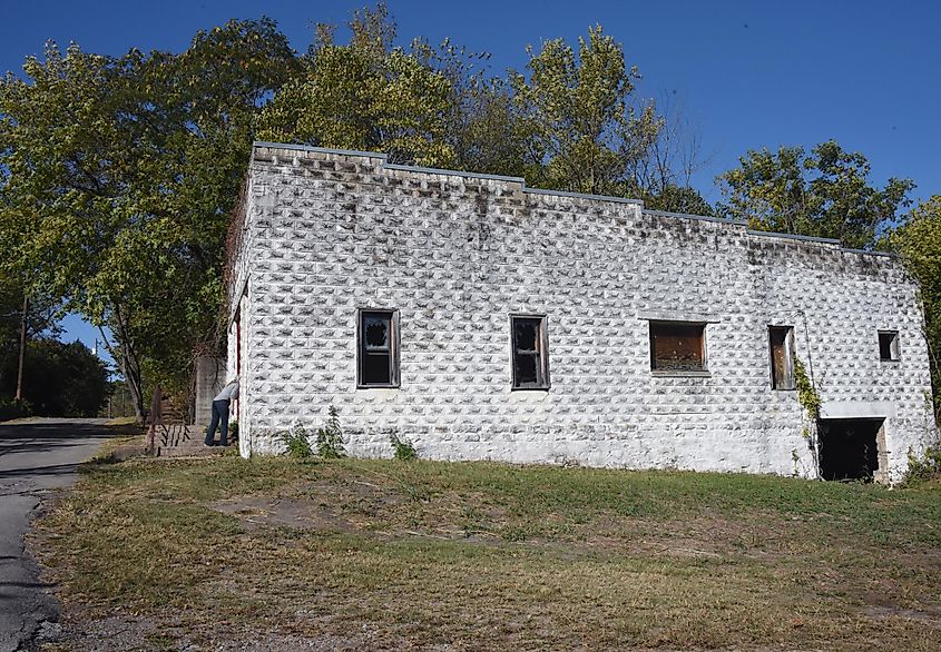 Visitor peeks in the window of the former funeral home of Pepper Sauce Alley, a ghost town within the town of Calico Rock, Arkansas.