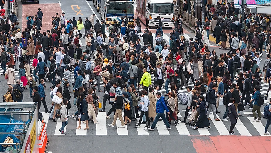 Shibuya crossing with many pedestrians and vehicles crossing the junction in Tokyo, Japan. Editorial credit: Cat Box / Shutterstock.com