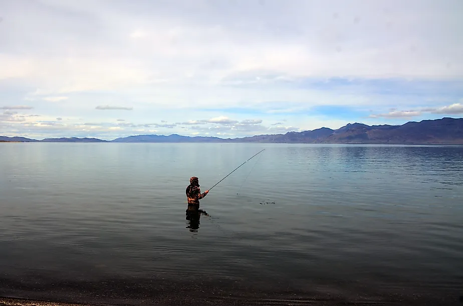 A fisherman fishing in Pyramid Lake which is a large natural lake and a world-class fishery in Nevada. Pyramid Lake, Nevada, United States Editorial credit: Daniel L. Locke / Shutterstock.com